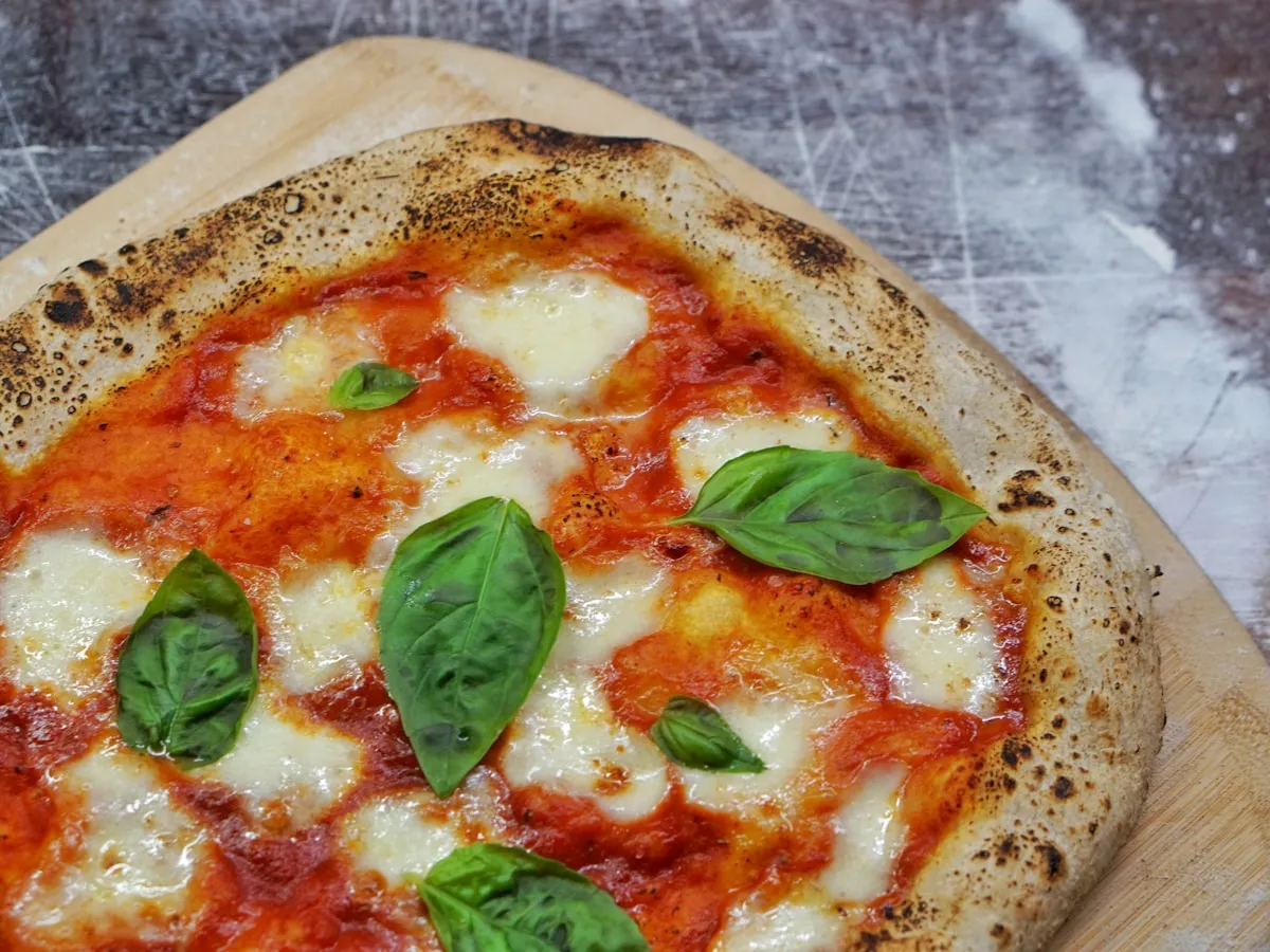 Fresh margherita pizza on a wooden board